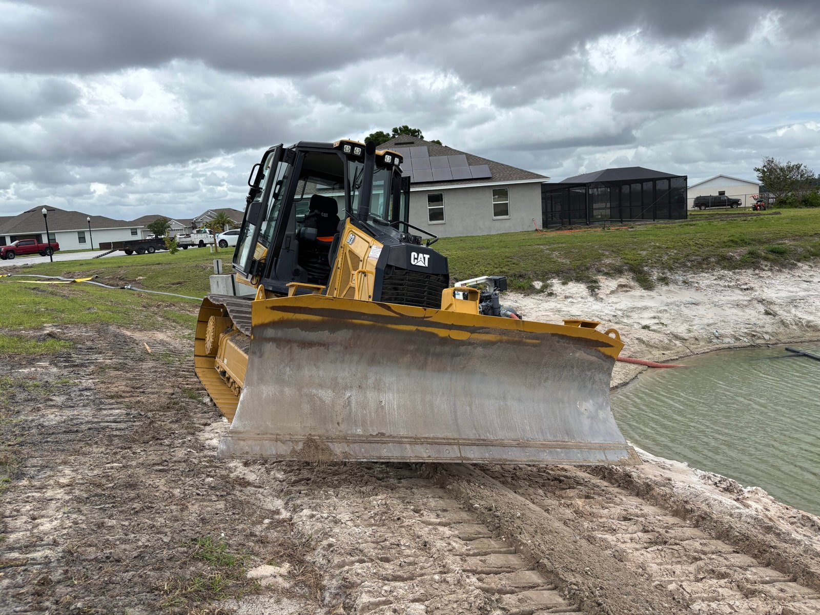 Cat D3 dozer grading retention pond to a 4 to 1 slope for proper drainage and erosion control