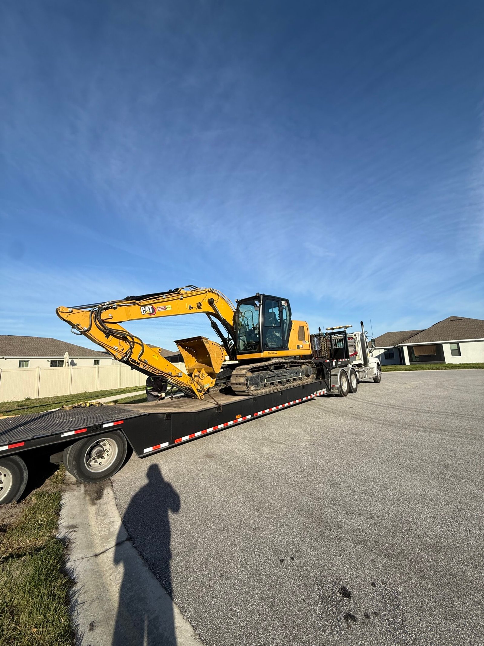 Excavator loading demolition debris into dumpsters during site cleanup in Central Florida