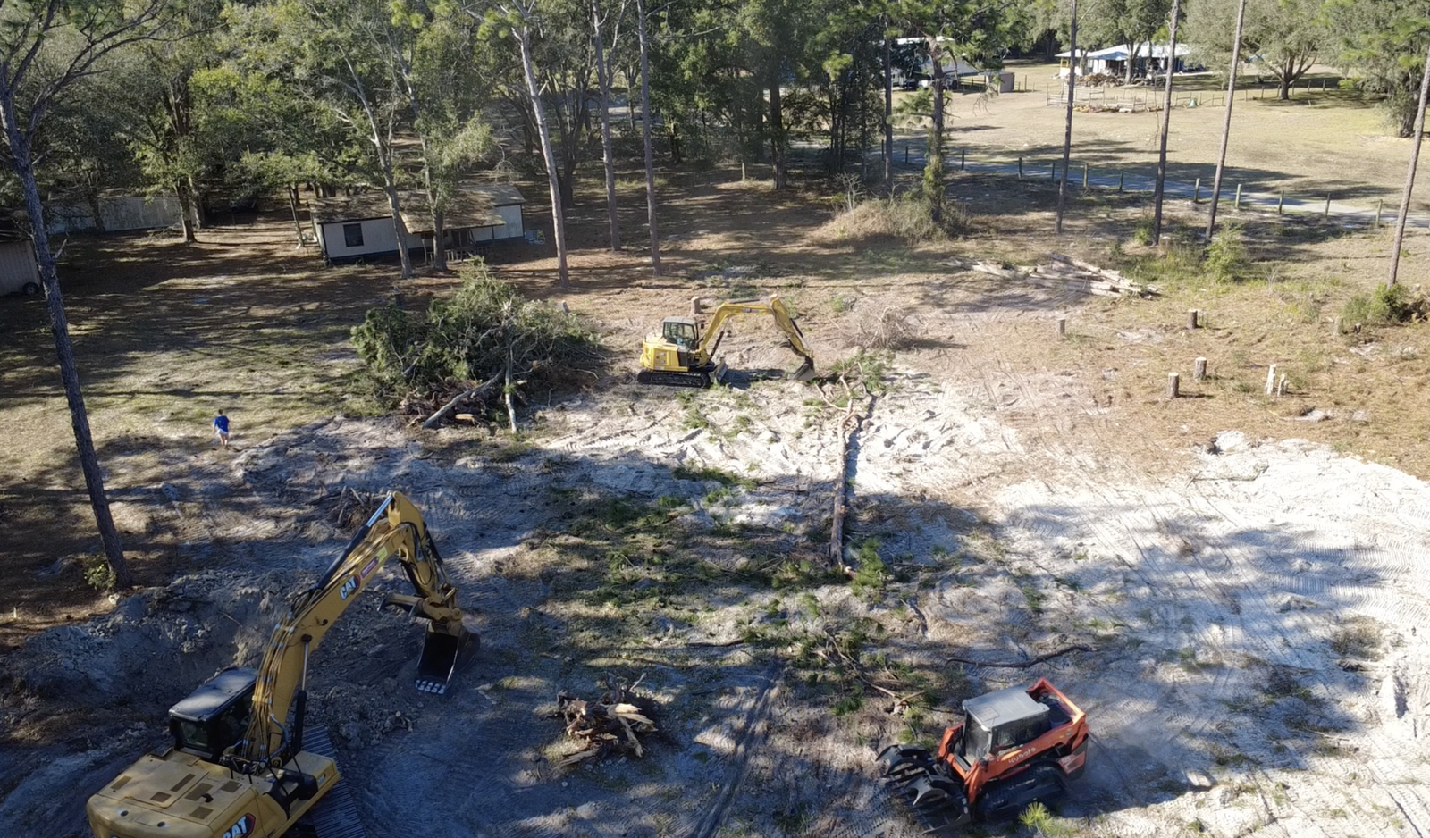 5 acre land clearing in Sumter County Florida using Cat 320 and Cat 308 excavators with skid steer removing trees, brush and stumps for site preparation